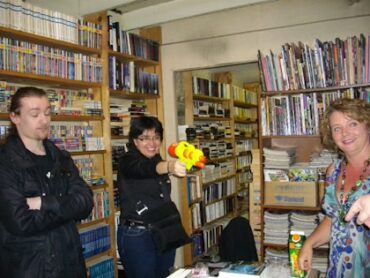 De son pistolet désintégrateur l'agent intergalactique Selene Verri tient en joue un dangereux espion Végan. L'ami Léo préfère ne pas voir ça.— avec Selene Verri et Valérie Simon.